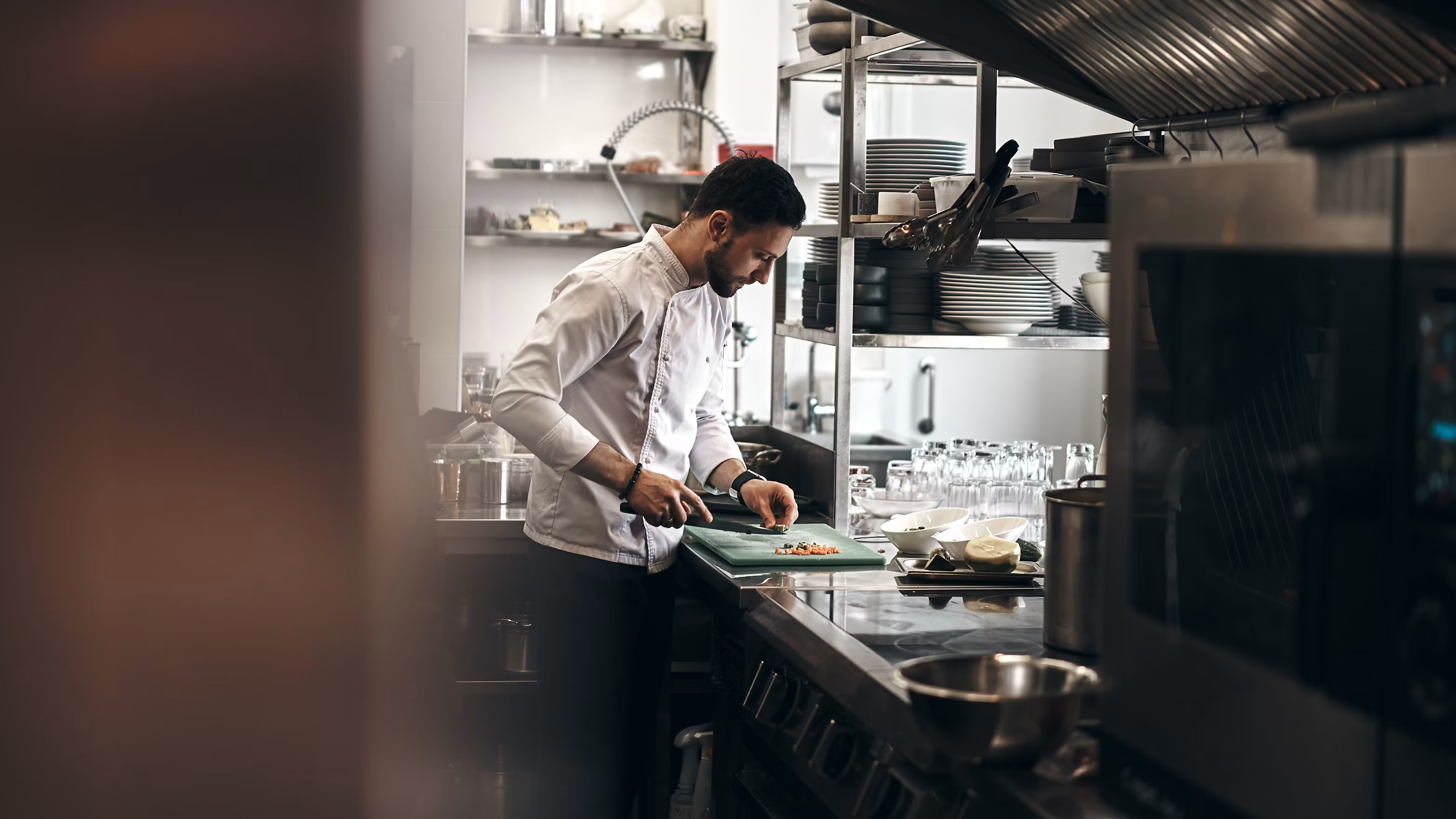 Chefs plating dishes together in a busy artisanal restaurant kitchen